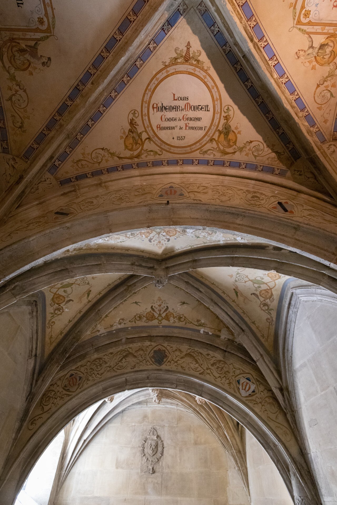 Plafond vouté en ogive au château de Grignan. On peut observer des décorations peinte dessus, nottamment un médaillon portant les mentions de l'ancien compte de Grignan, Louis Adhémar de Monteil