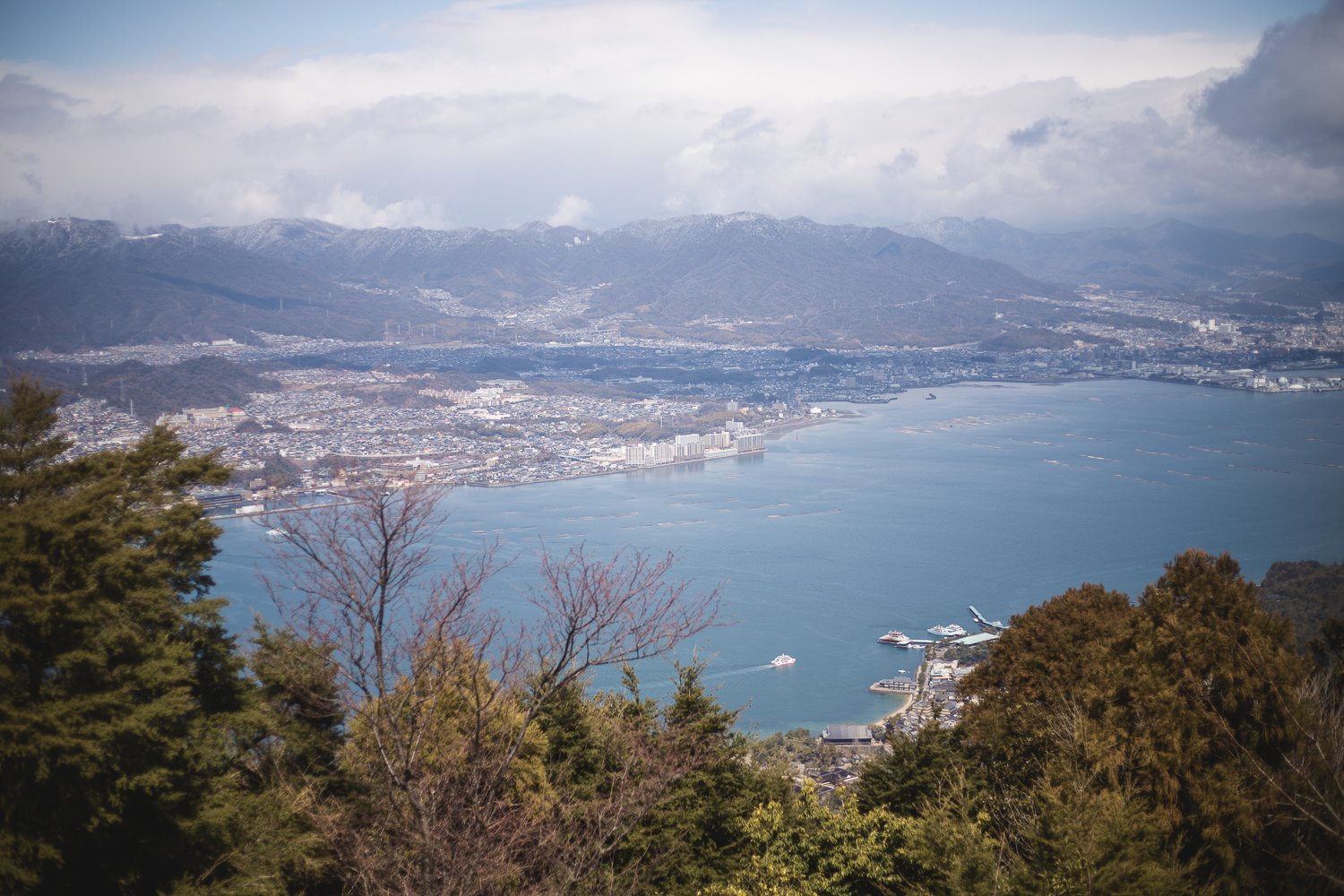 Vue sur la mer et Hiroshima depuis le sommet du Mont Misen. En  contrebas on aperçoit le village de Miyajima avec des ferrys en train de faire la navette.