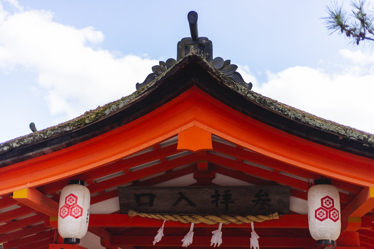Détail du toit du sanctuaire Itsukushima à Miyajima. L'accent est mis sur la forme du toit et la couleur vermillon du bois en dessous.