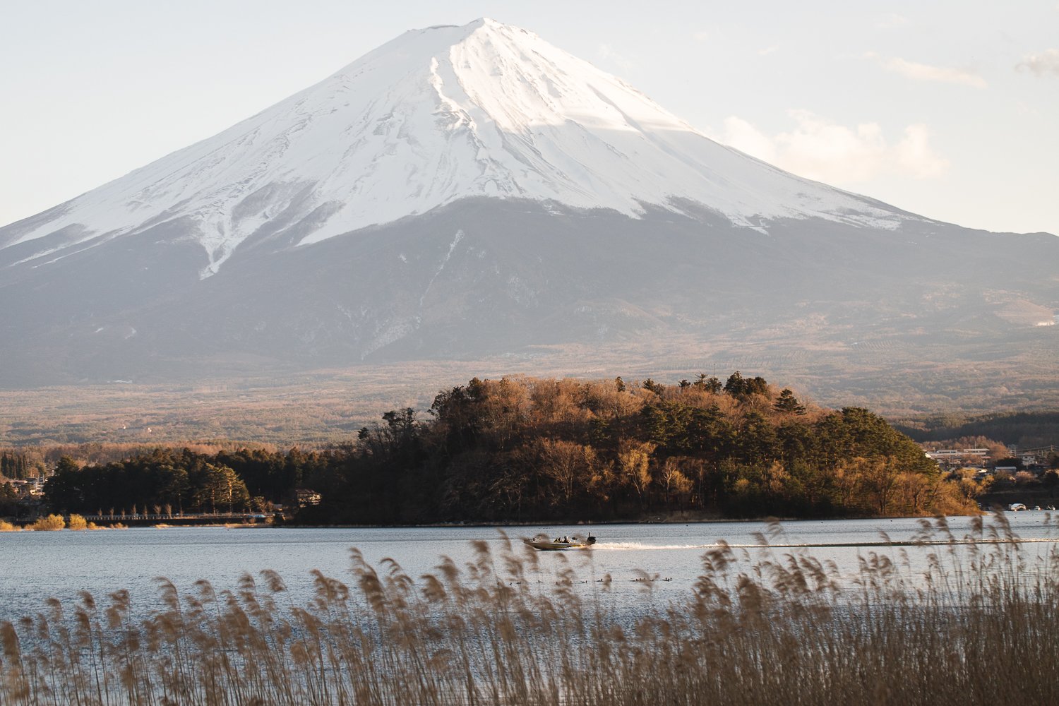 Un bateau à moteur passe sur le lac Kawaguchi devant le Mont Fuji
