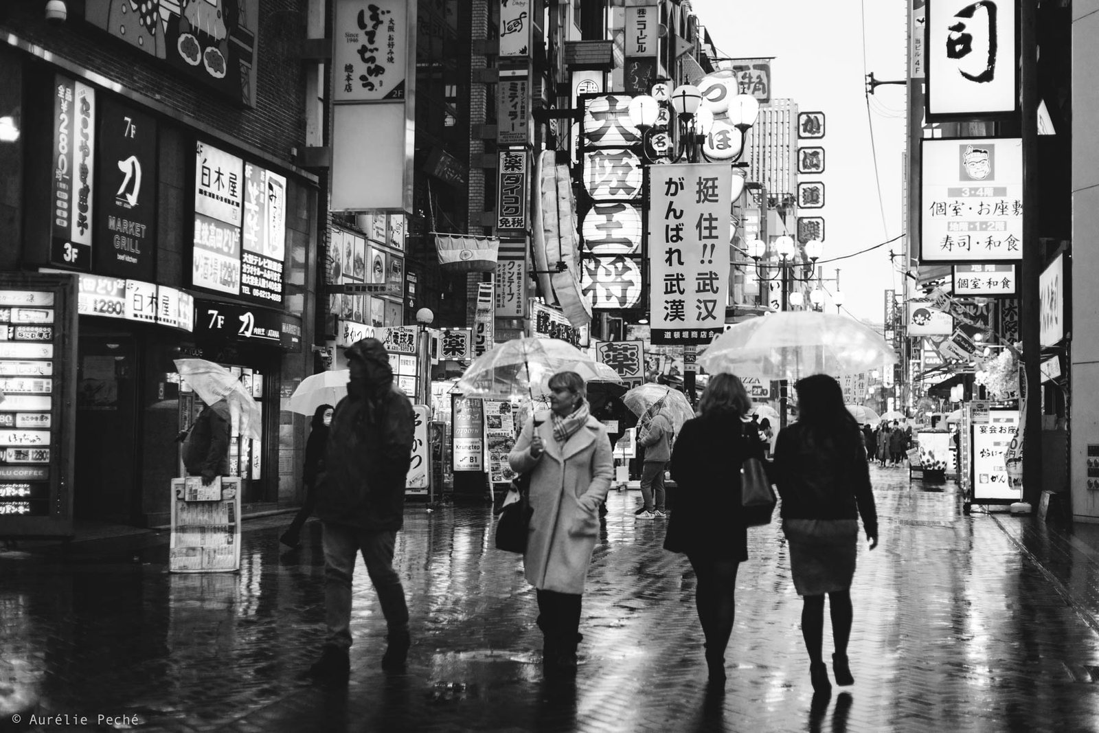 Groupe de personne dans les rues d'Osaka avec des parapluies