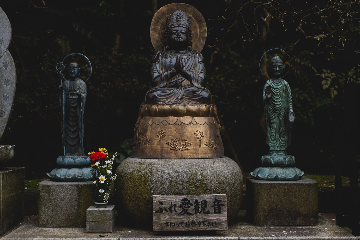 Trois petites statues et un bouquet de fleurs