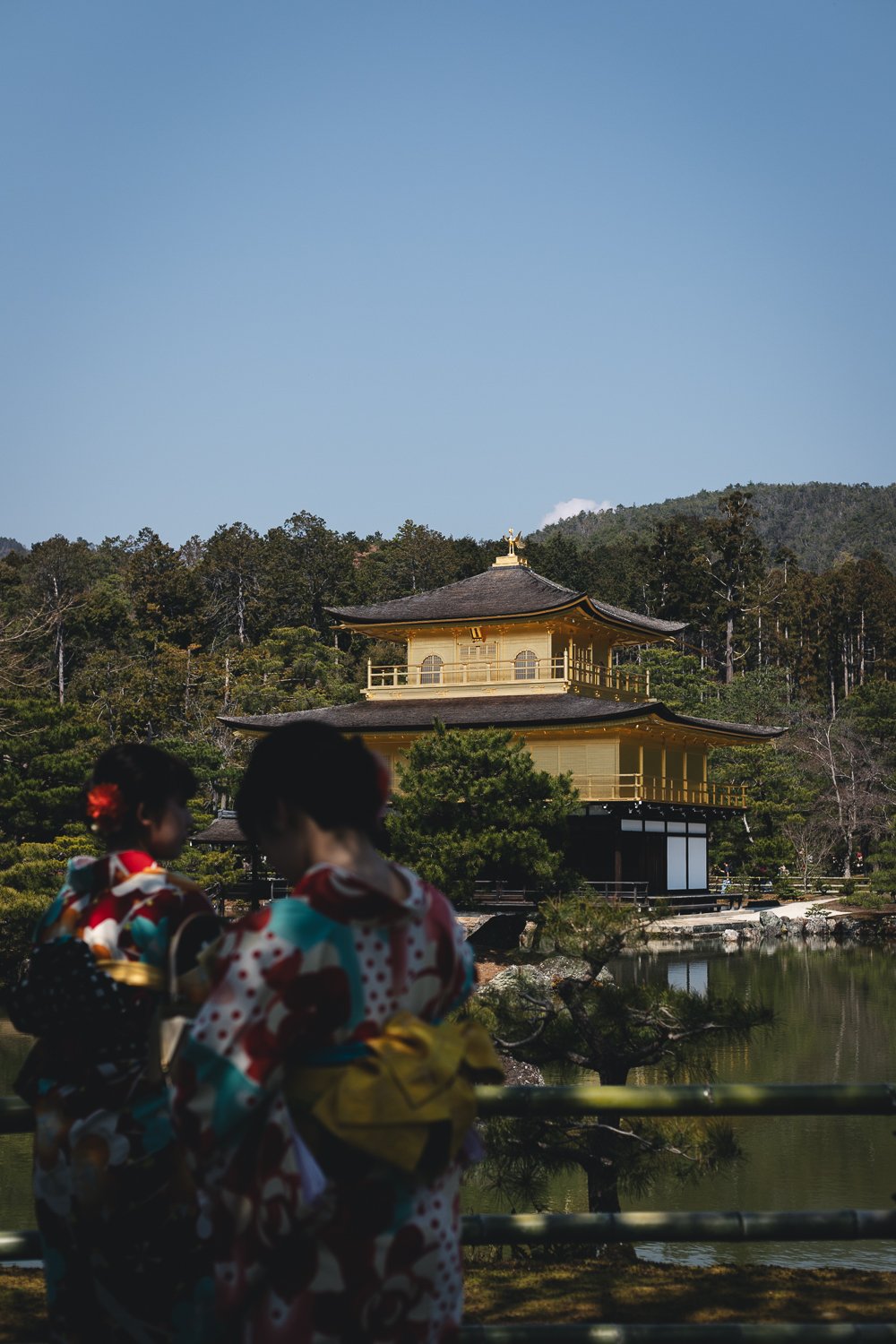 Le pavillon d'or avec au premier plan deux personnes en yukata vues de dos