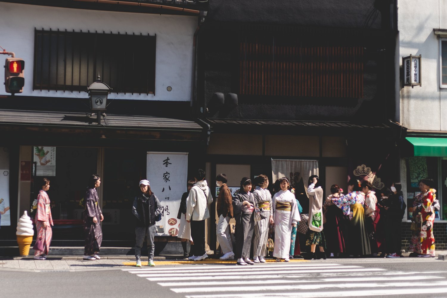 Une foule se masse devant un passage pour piétons à Kyoto, la plupart en kimono et yukata.