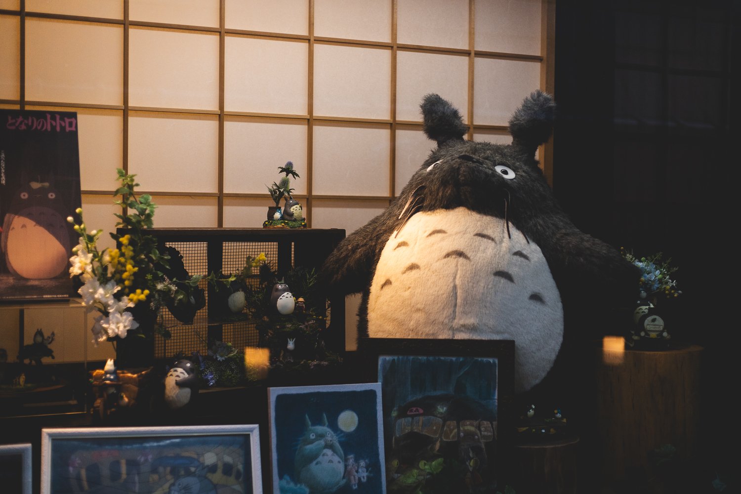 Un gros Totoro entouré de petits Totoro et de cadres de peintures du film