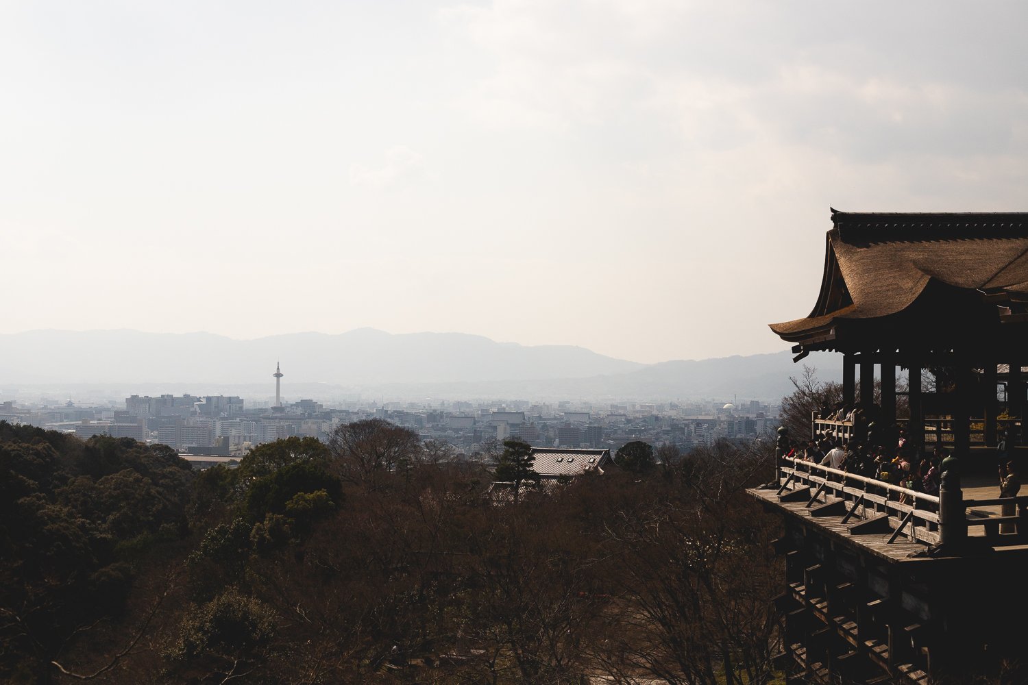 Une vue sur Kyoto avec sur le côté le grand hall du Kiyomizu-dera et au loin la ville avec la tour de Kyoto bien visible.