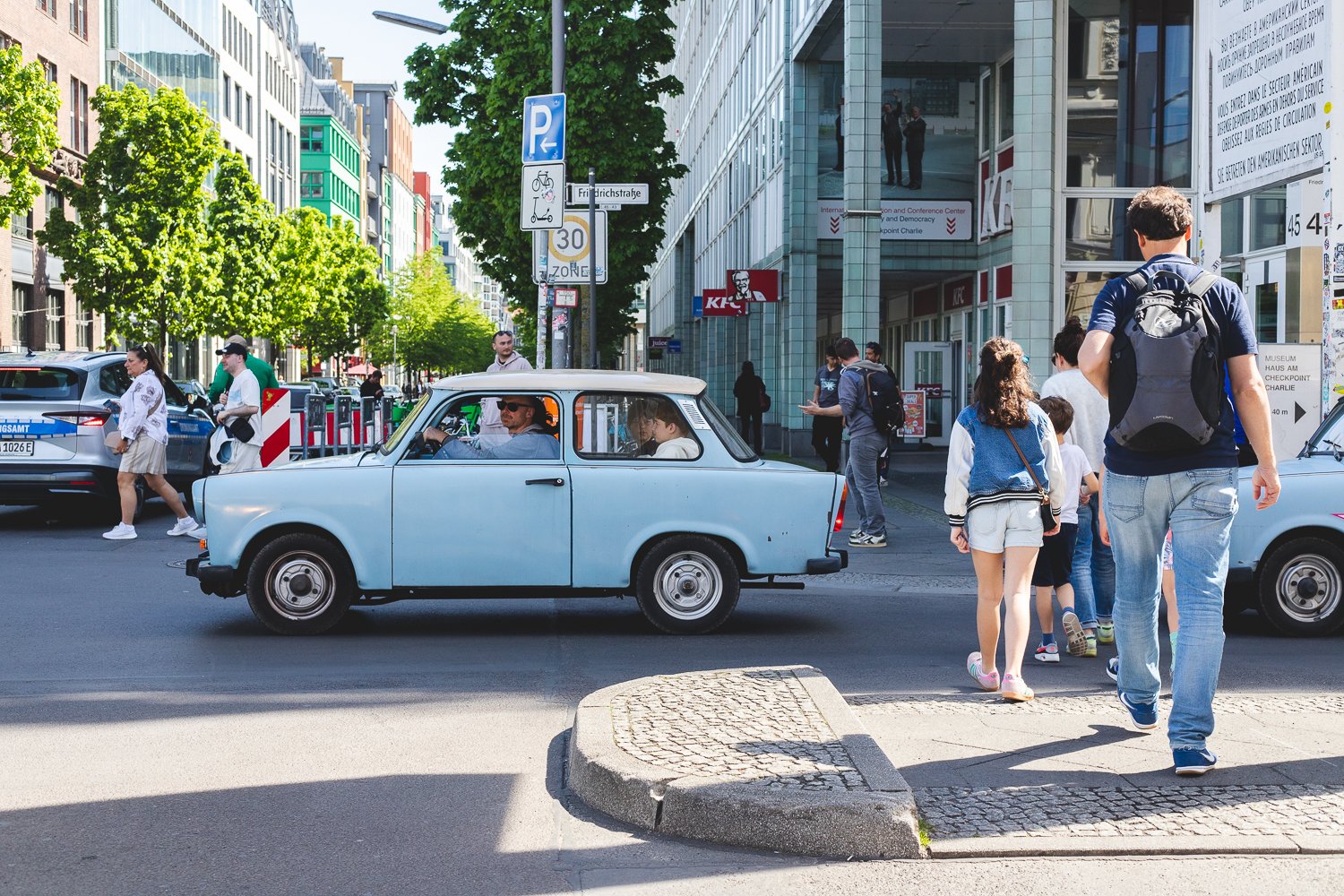 Touristes faisant un tour en Traban, la voiture emblématique de la RDA, au CheckPoint Charlie